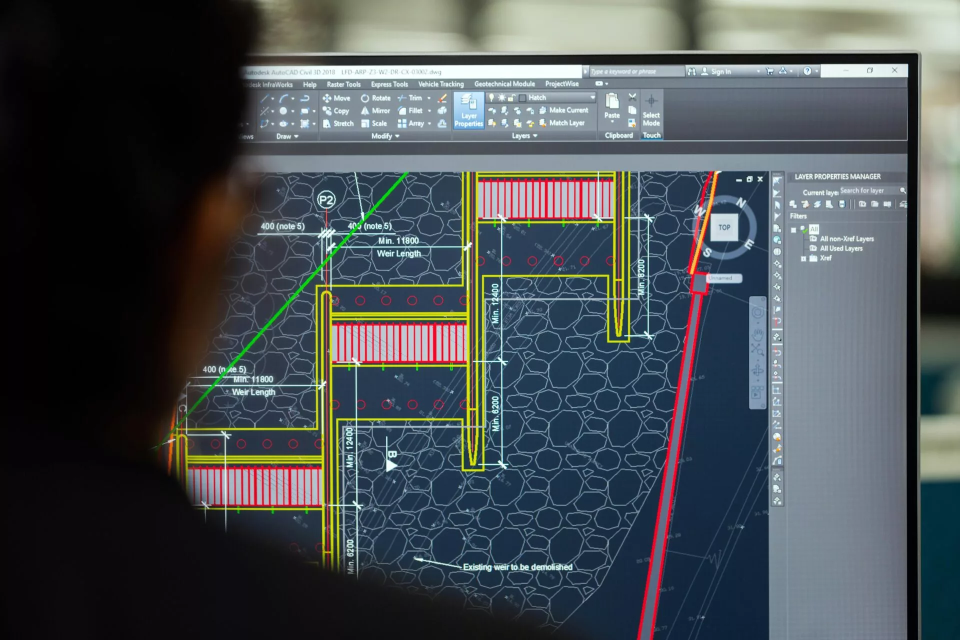 Инженер за работой в AutoCAD на экране монитора.